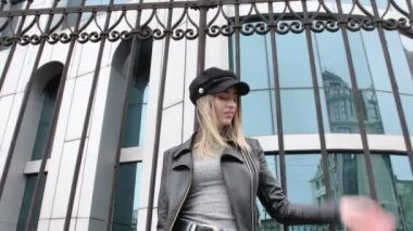 Fransız tarzı bir Fransız kadın, şehir merkezinde küçük bir etekle yürüyor, elinde bir çanta, ayakkabılarını düzeltmek için eğiliyor, sokak lambalarının etrafında dönüyor, gülümsüyor.