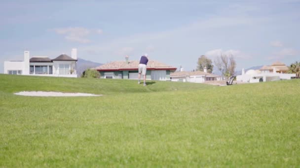 男子在高尔夫球场上挥动高尔夫球杆 — 图库视频影像