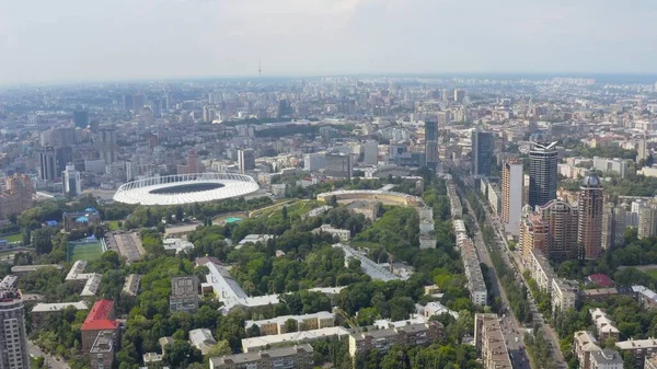 Stadium in a green city, a terrible sky and the sun\'s rays. Kyiv, Ukraine - Cityscape Aerial Flight