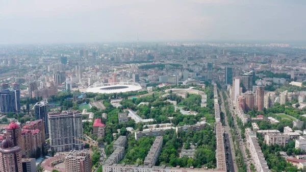Stadium in a green city, a terrible sky and the sun\'s rays. Kyiv, Ukraine - Cityscape Aerial Flight