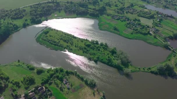 Un lago con un'isola in mezzo brilla al sole e si arriccia come un serpente — Video Stock