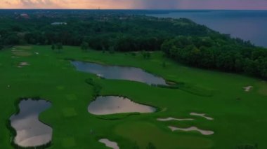 Özel konutta golf sahasının üzerinde renkli bir günbatımı.