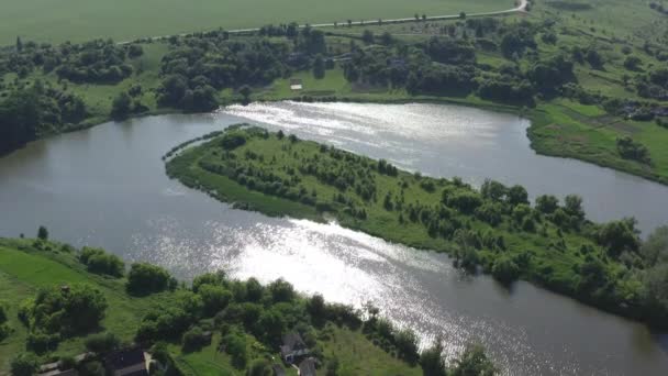 Un lago con una isla en el medio brilla al sol y se enrosca como una serpiente — Vídeos de Stock