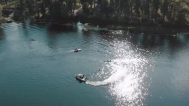 İnsanlar kano yapıyor ve nehirde hızlı teknelerle kalkıyor.