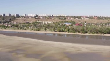 Yazın sanayi şehri. Ufukta deniz kenarında metalürjik bir bitki var.