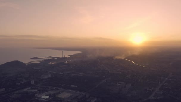 Puesta de sol en la ciudad industrial. En el horizonte, una planta metalúrgica cerca del mar — Vídeos de Stock