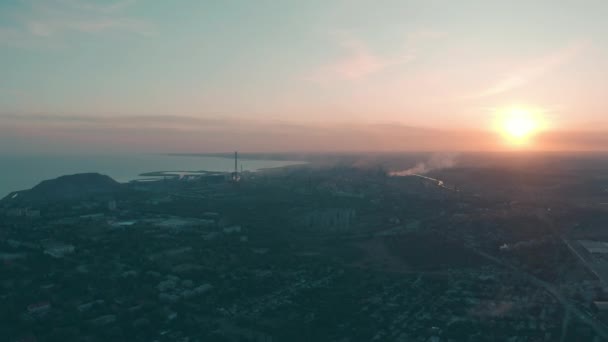 Закат в Индустриальном городе. На горизонте металлургический завод у моря — стоковое видео