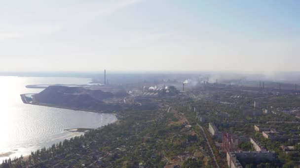 Coucher de soleil dans la ville industrielle. A l'horizon, une usine métallurgique près de la mer — Video