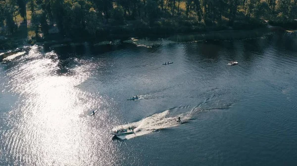 İnsanlar kano yapıyor ve nehirde hızlı teknelerle kalkıyor.