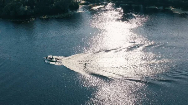 İnsanlar kano yapıyor ve nehirde hızlı teknelerle kalkıyor.