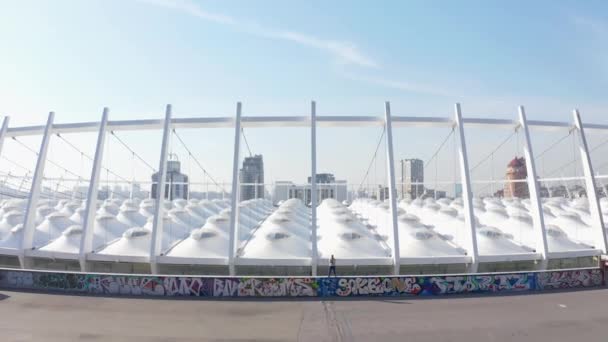 Helikopter vliegen weg van een persoon naar een brede hoek van het stadion — Stockvideo