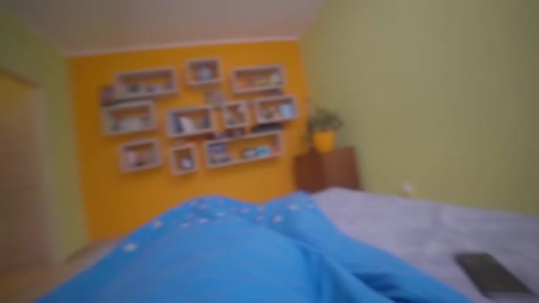 Хлопець прокидається на будильник о сьомій ранку і одягає тапочки — стокове відео