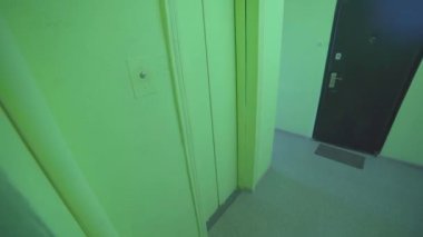 Adam Sovyetlerin eski karanlık asansörüne giriyor, asansörden çıkıyor. Bakış açısı