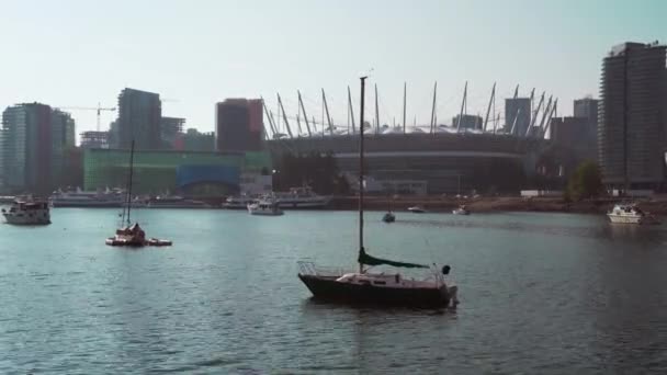 На якорі у Ванкуверській затоці стоїть яхта. Арена Роджерс на задньому плані.. — стокове відео