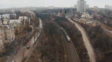 Paslı bir elektrikli tren şehir boyunca hareket eder.