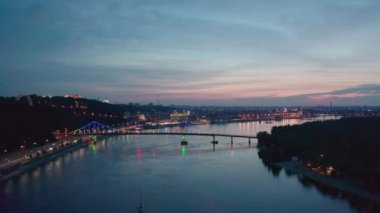 Gece manzarası. Kyiv 'de nehir ve rıhtım üzerindeki renkli köprü
