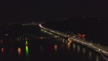 Gece manzarası. Kyiv 'de nehir ve rıhtım üzerindeki renkli köprü