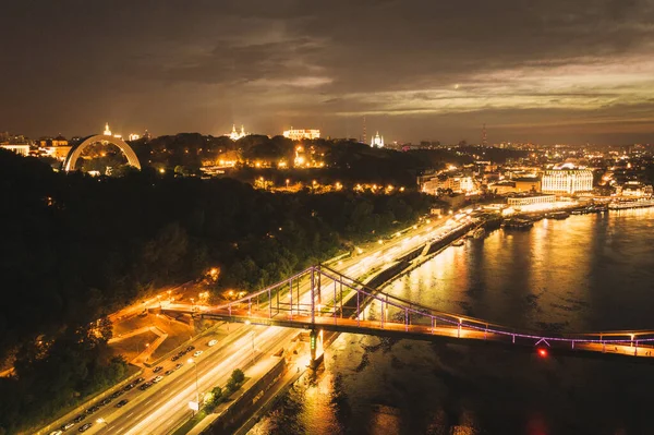 Gece manzarası. Kyiv 'de nehir ve rıhtım üzerindeki renkli köprü
