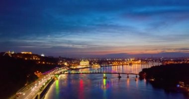 Gece manzarası. Kyiv 'deki nehir ve rıhtım yolu üzerinde renkli parlak bir köprü.