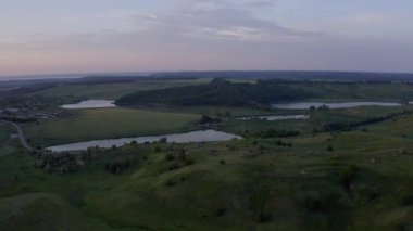 Gölleri ve yeşil tepeleri olan güzel yaz günbatımı