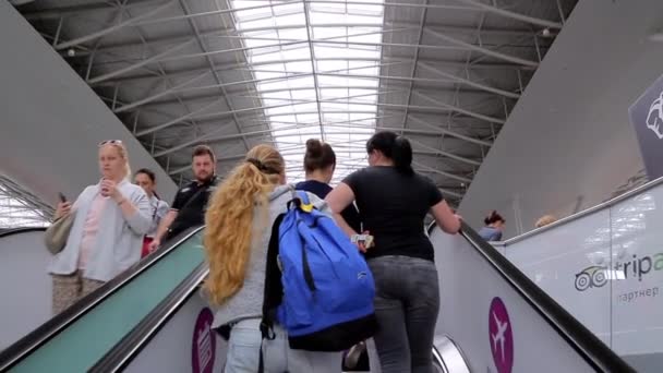 As pessoas se levantam e caem em uma escada rolante no aeroporto internacional de Boryspil . — Vídeo de Stock