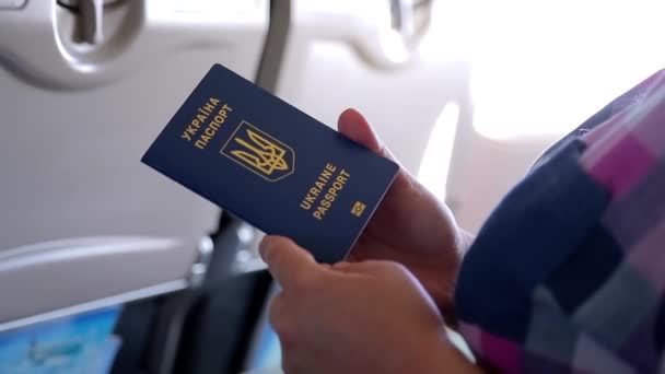 Ουκρανία διεθνές διαβατήριο στα χέρια μιας γυναίκας στο αεροπλάνο. — Αρχείο Βίντεο