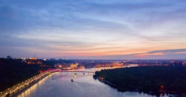 Gece manzarası. Kyiv 'deki nehir ve rıhtım yolu üzerinde renkli parlak bir köprü.