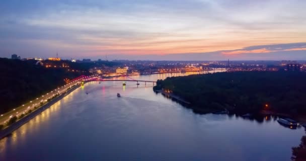 Nattstadsbilden. färgglada glödande led bro över floden och kaj väg i Kiev — Stockvideo