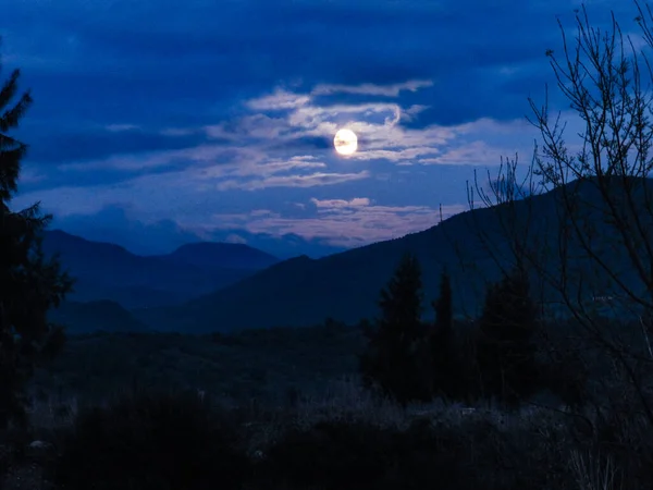 Volle Maan Een Midden Bewolkte Hemel Tussen Hoge Bergen Stockafbeelding