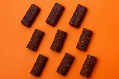 Turuncu arka planda çikolatalı şekerler, tatlı.