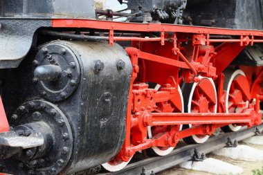 Demiryolunda, arka planda bir buharlı lokomotifin metal tekerlekleri