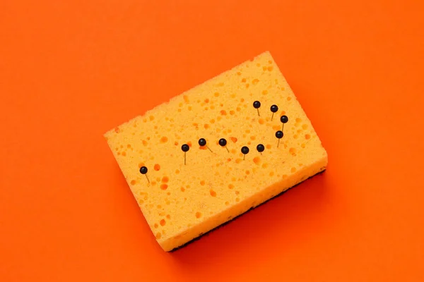 Abstract question mark made by needles in a sponge for washing dishes. The concept is should your man wash the dishes?