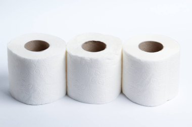 Arka planda üç rulo tuvalet kağıdı
