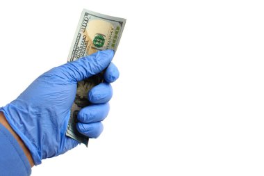 Doktorun elindeki tıbbi eldiven beyaz arka planda, izole edilmiş dolarları tutuyor. Yüksek tedavi maliyeti kavramı