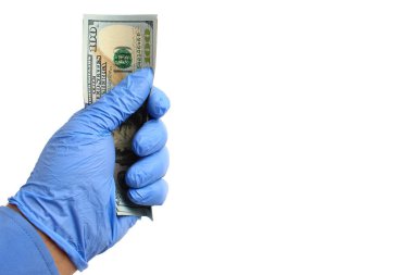Doktorun elinde tıbbi bir eldiven var. Beyaz arka planda, izole bir şekilde dolarları tutuyor..