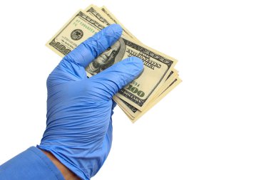 Tıbbi eldivendeki bir el, beyaz arka planda, izole bir şekilde Amerikan doları taşır. Salgın intikam kavramı