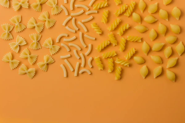 Verschiedene Nudelsorten Auf Orangefarbenem Hintergrund — Stockfoto