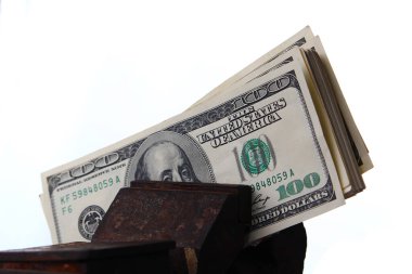 Beyaz arka planda eski bir mengeneye sıkıştırılmış Amerikan doları.