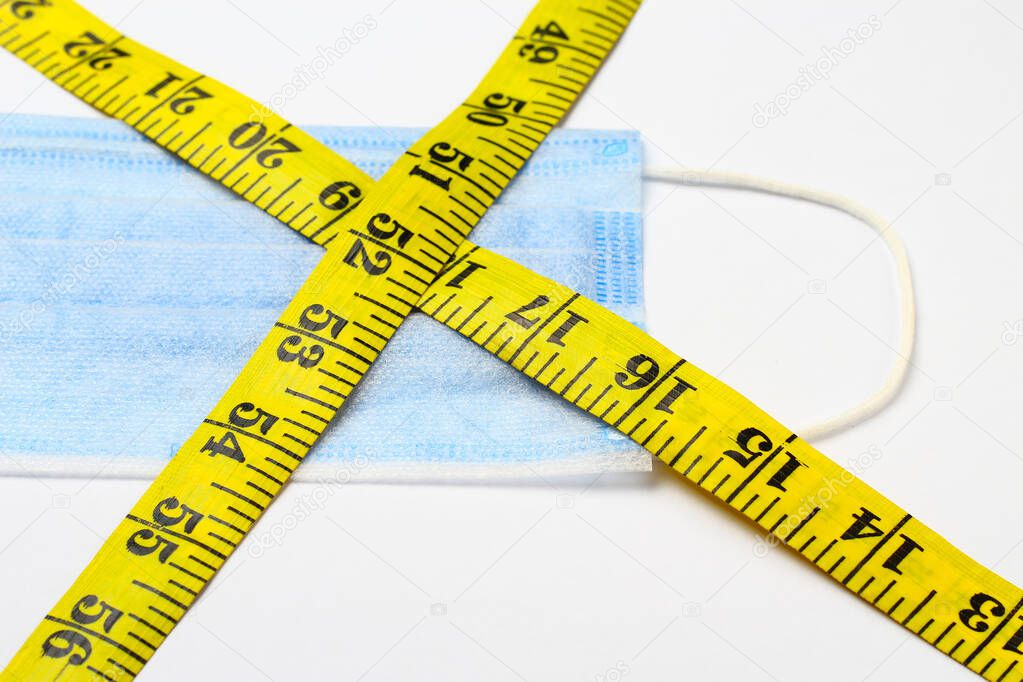 Centimeter or inch tape and medical surgical mask, background