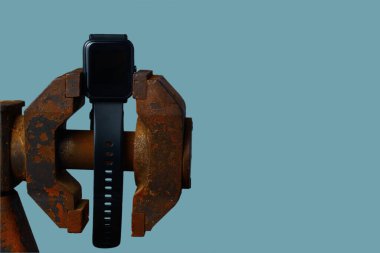 Siyah akıllı saat mengeneye sıkıştırılmış. Acil durum kavramı, zaman tükeniyor.