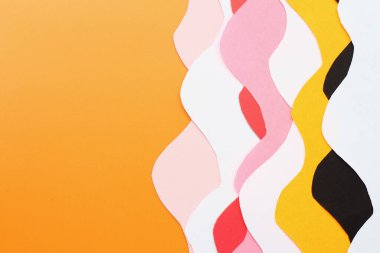 Turuncu arkaplanda metin için boşluk ve renkli kağıdın soyut kıvrımlı çizgileri, arkaplan