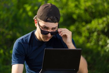 Parkta çalışan dizüstü bilgisayarı olan sanal gerçeklik tasarımcısı. Kavram: Gözlerime inanmıyorum.
