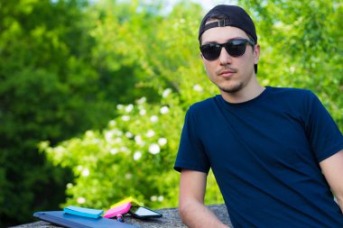 Genç serbest çalışan, beton kaldırıma yaslandı ve doğanın tadını çıkarırken işten çıktı.