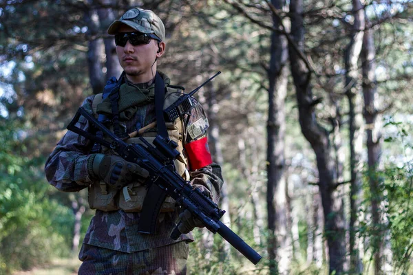 身穿军服的软绵绵的士兵在针叶林中移动 — 图库照片