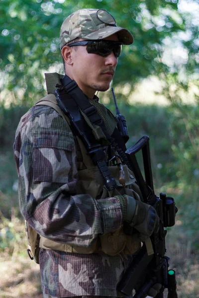 軍の制服を着たエアソフトの兵士が森の影に身を隠した — ストック写真