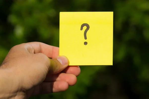 Sticker with a question mark in hand with copy space for text or inscription. Concept: what, where when and why