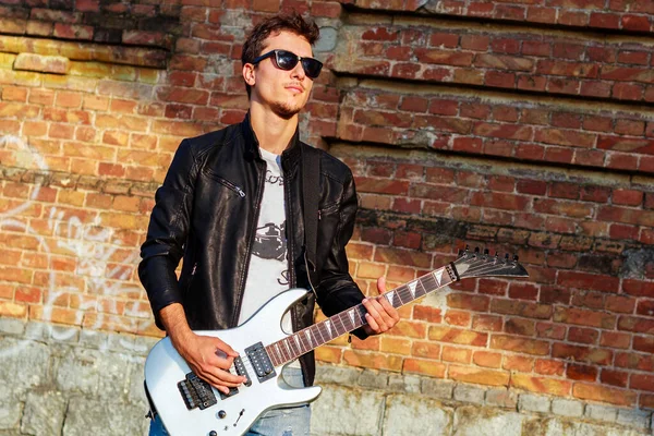 Gitarlı Deri Ceketli Güneş Gözlüklü Genç Bir Adam — Stok fotoğraf