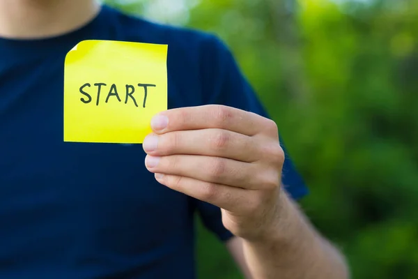 Start这个字写在一个男人手上的黄色贴纸上 创办新企业的概念 — 图库照片