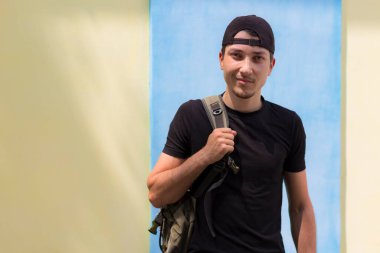 Bir eğitim kurumunun duvarının arkasında duran genç bir öğrenci. Üniversiteye dönüş kavramı