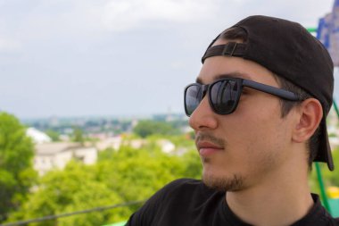 Dönme dolaba binmiş bir adam şehrin kuş bakışı manzarasından hoşlanır.